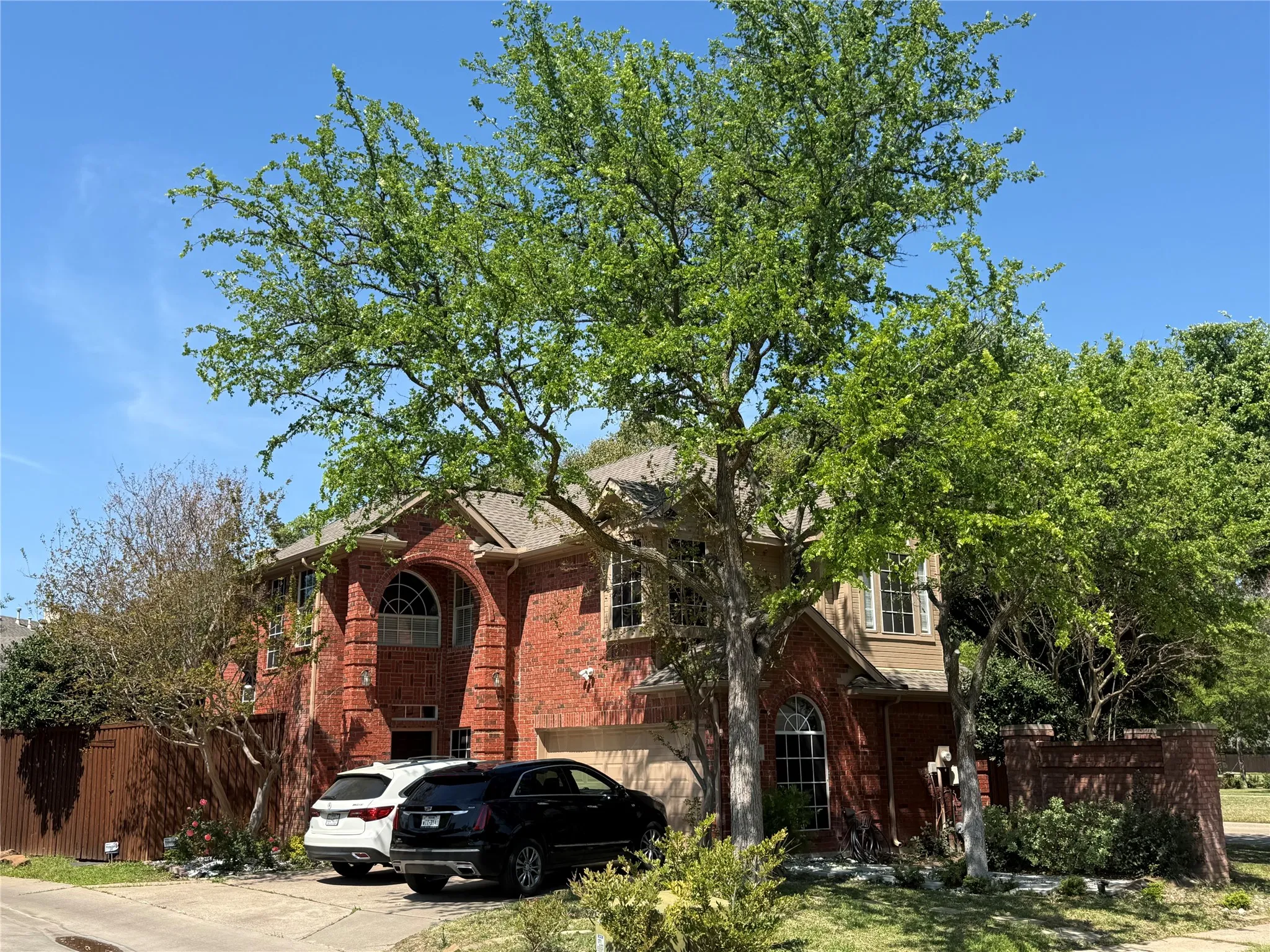 View of front facade with brick siding, concrete driveway, and a garage