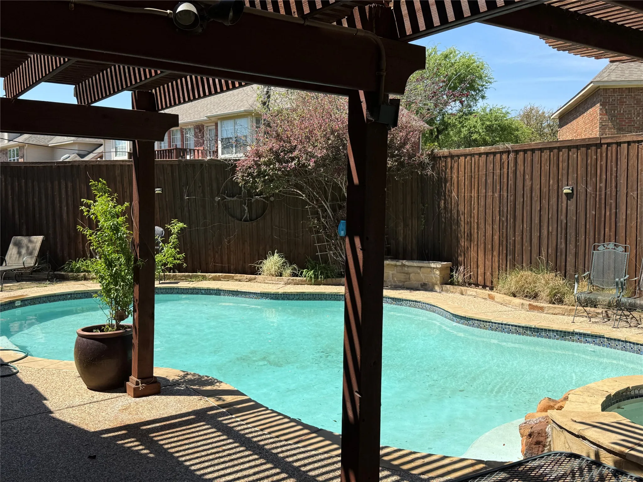 View of swimming pool with a pergola, patio surround, and a fenced backyard