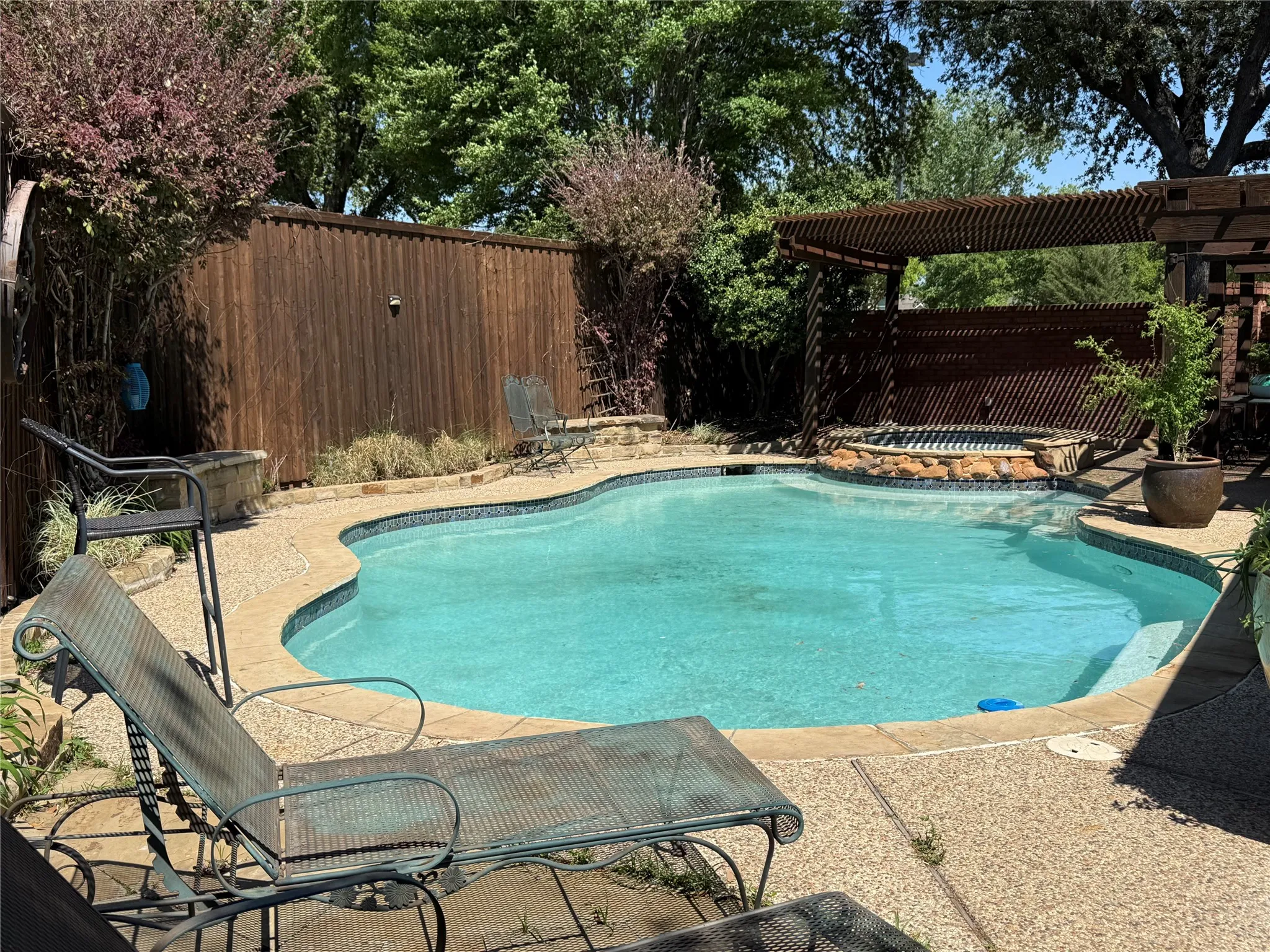 View of pool with patio surround, a fenced backyard, an in-ground hot tub, and a pergola
