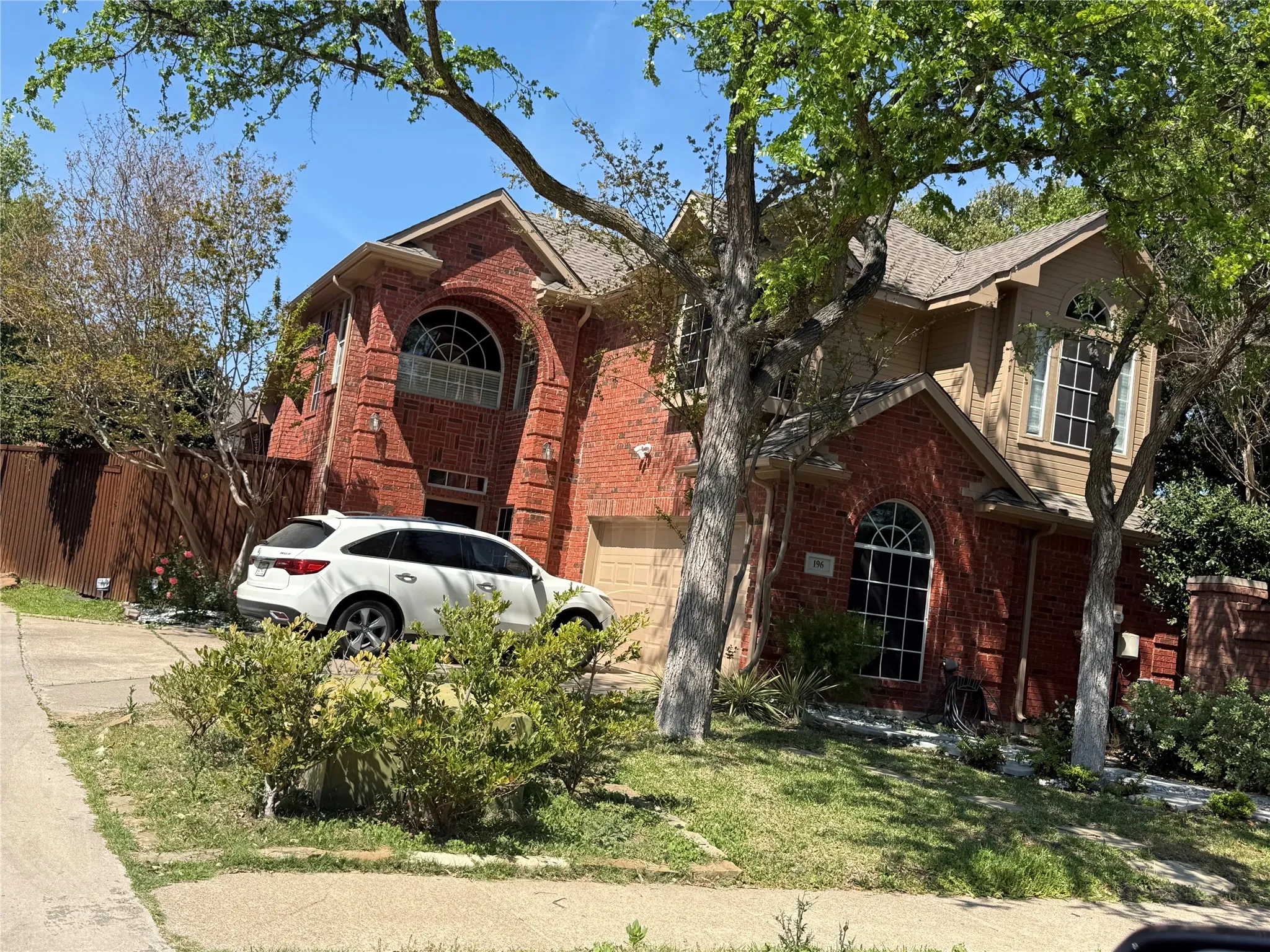 Traditional-style house with brick siding, an attached garage, and driveway