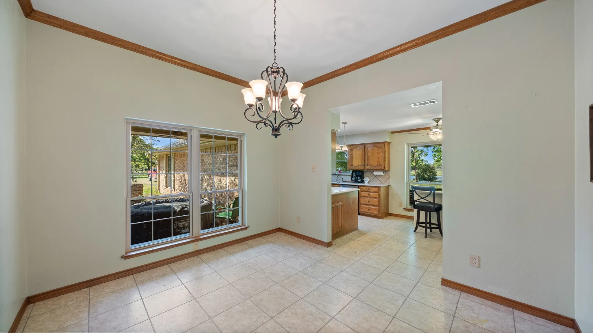 Unfurnished dining area featuring crown molding, a chandelier, and light tile patterned floors