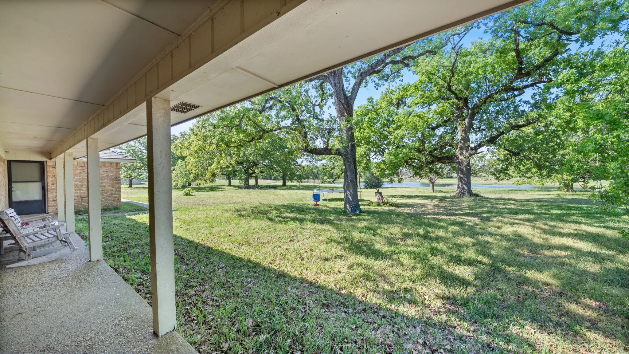 View of green lawn with a patio area