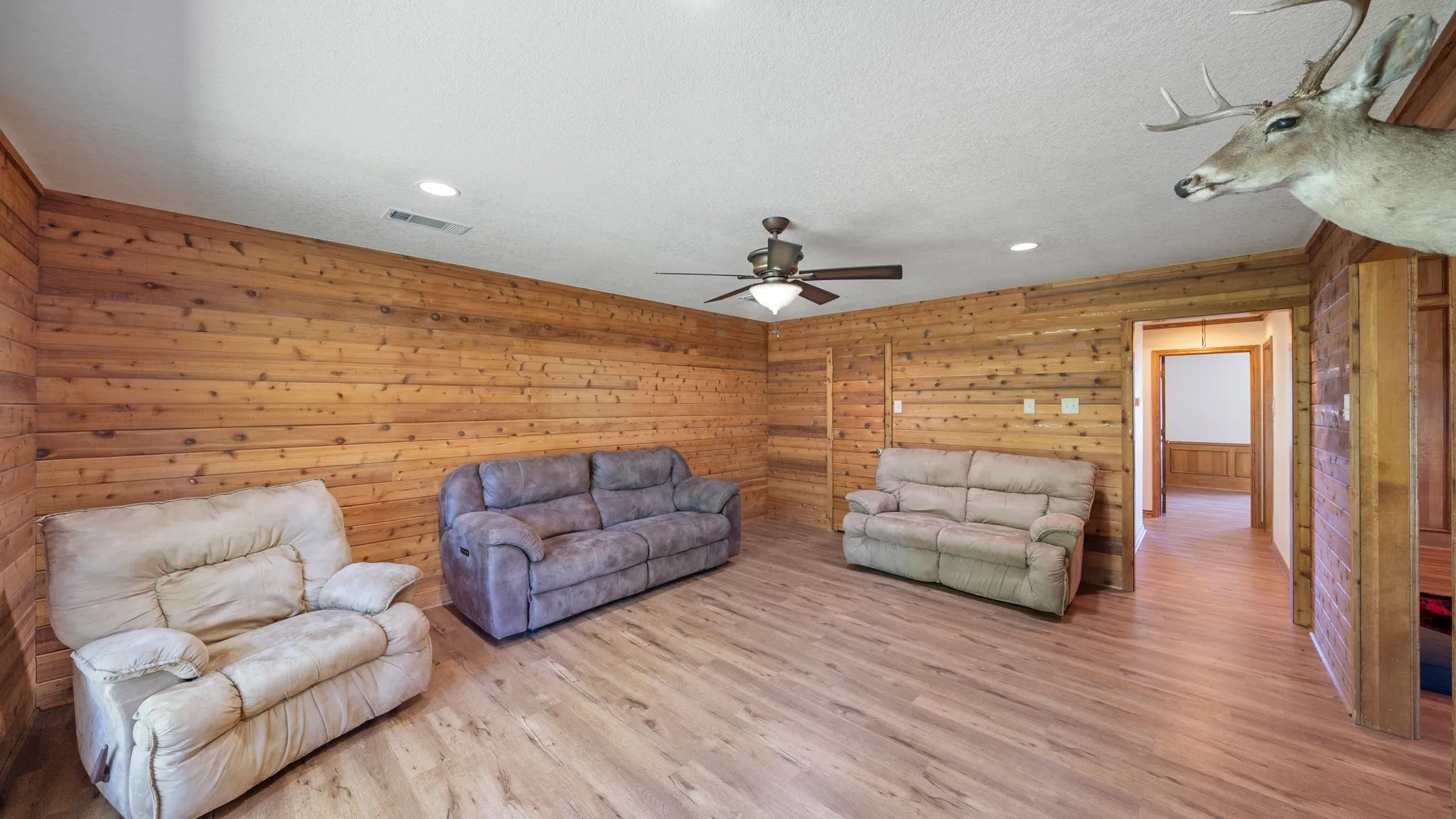 Living area featuring wood finished floors, wooden walls, recessed lighting, and a ceiling fan