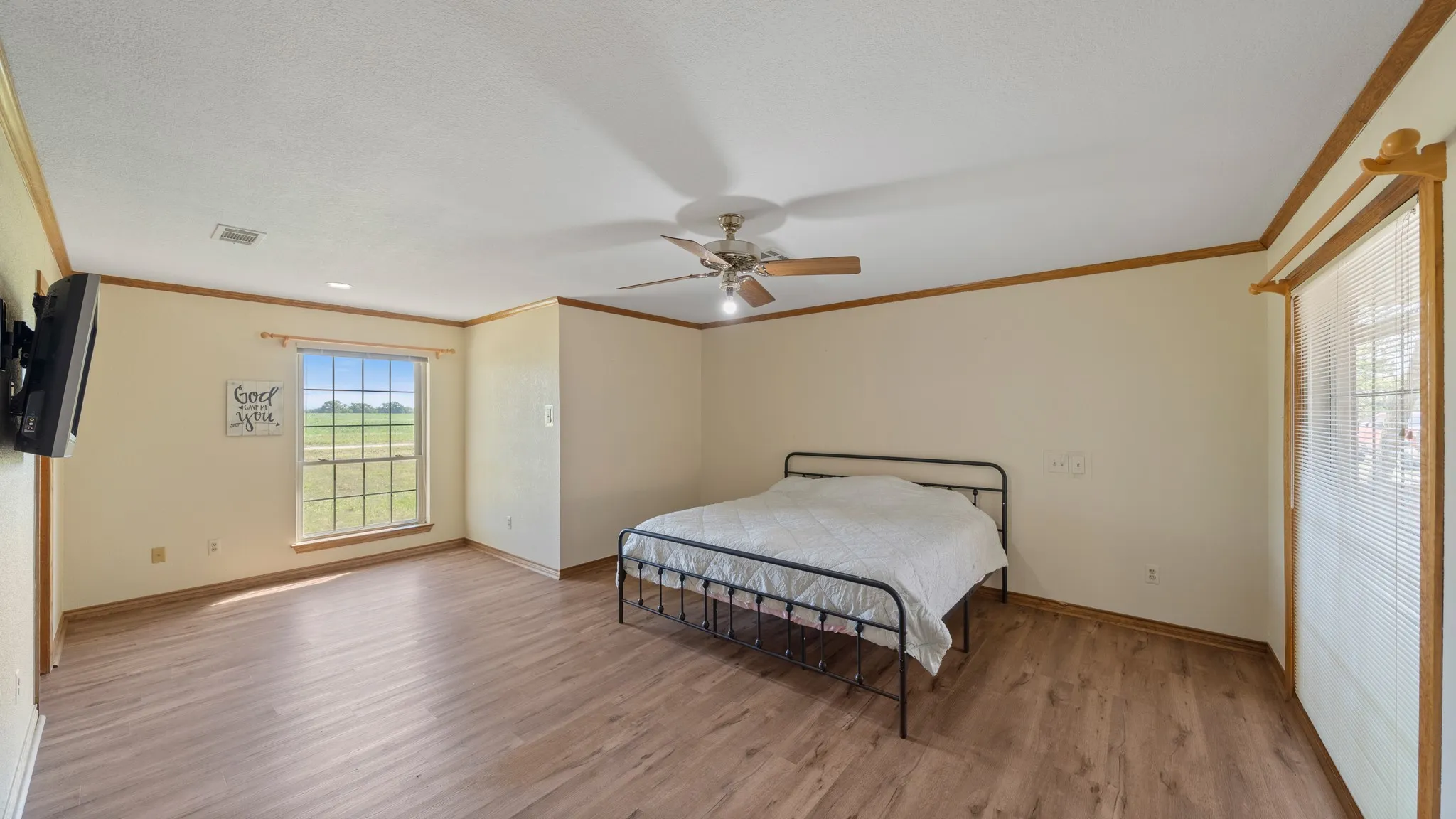Master Bedroom with light wood-style floors, ceiling fan, and crown molding