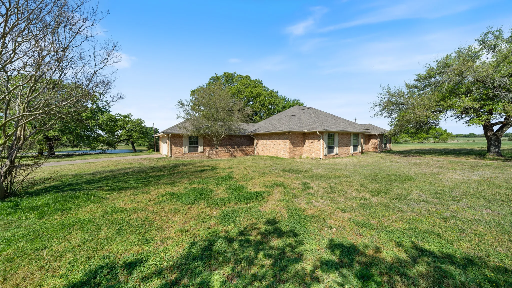 View of side of property with a yard and brick siding
