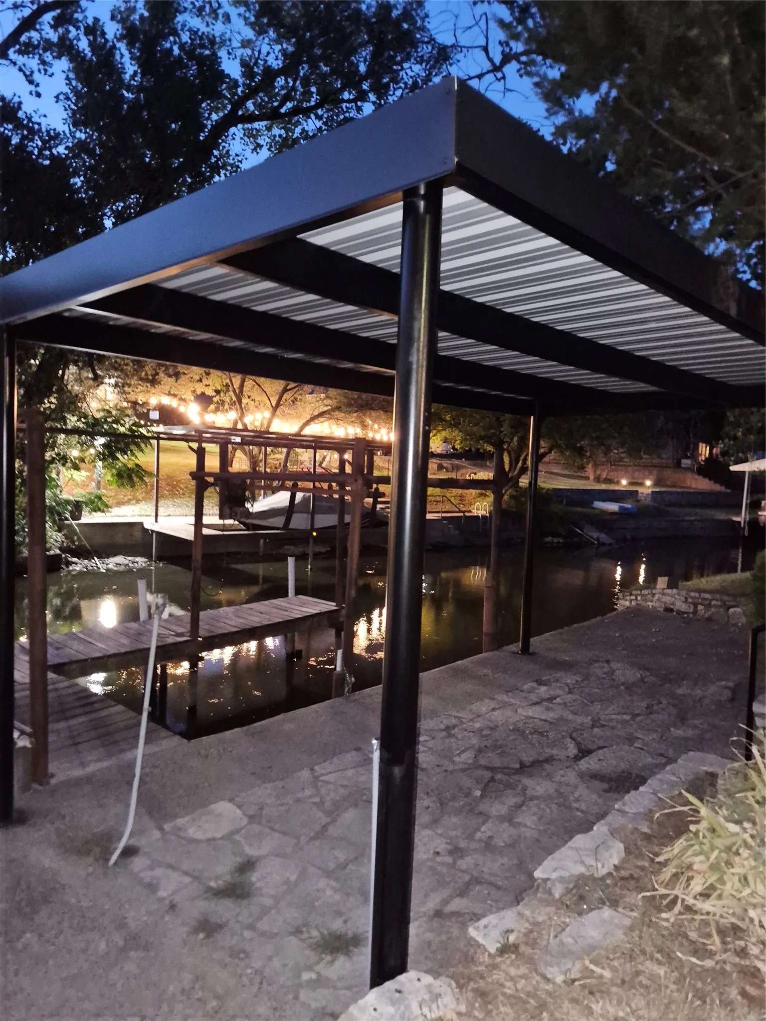 Covered dock structure with a corrugated metal roof, supported by robust metal posts