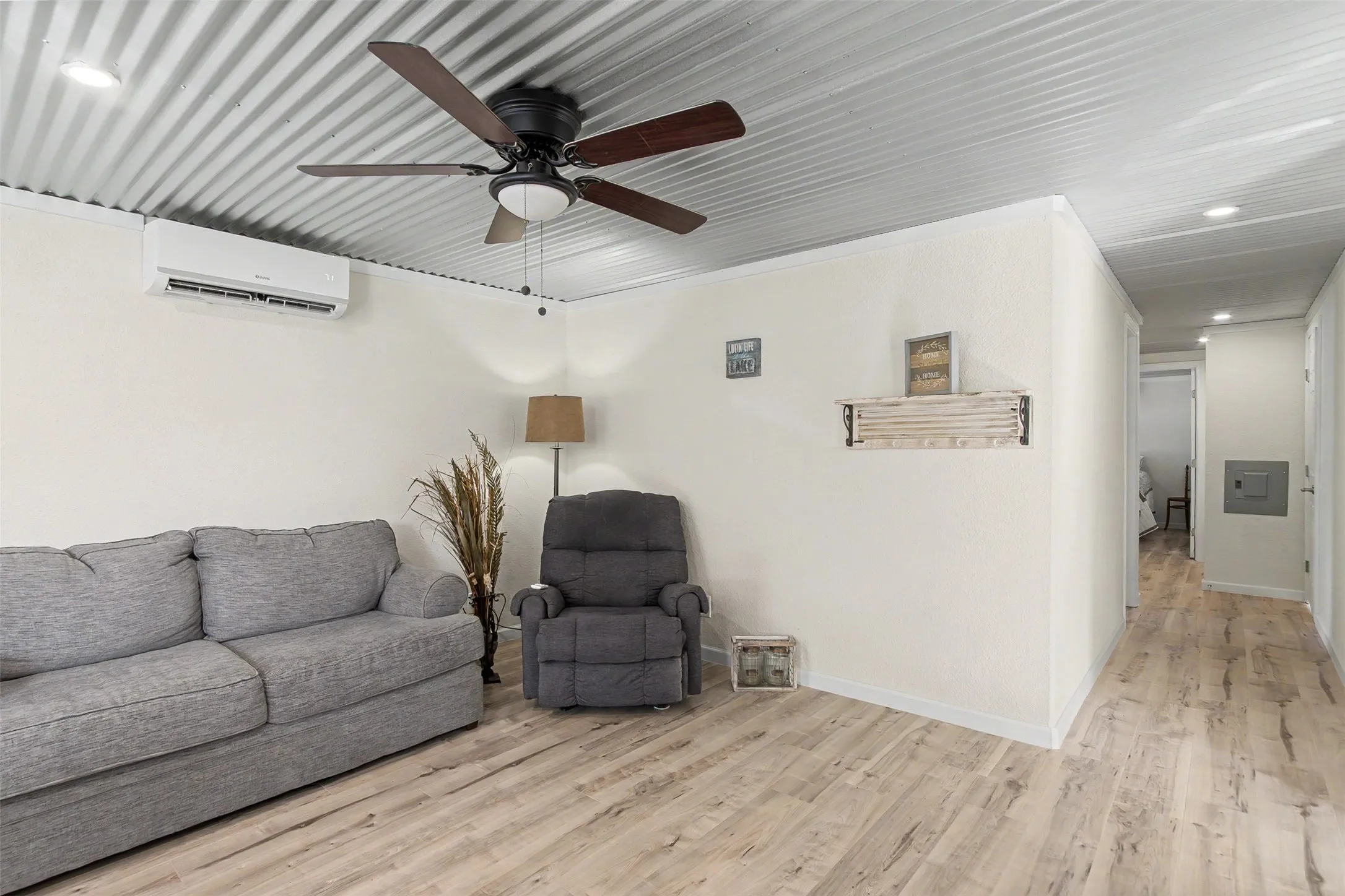 Spacious interior featuring wood-finish flooring, a corrugated metal ceiling, and recessed lighting