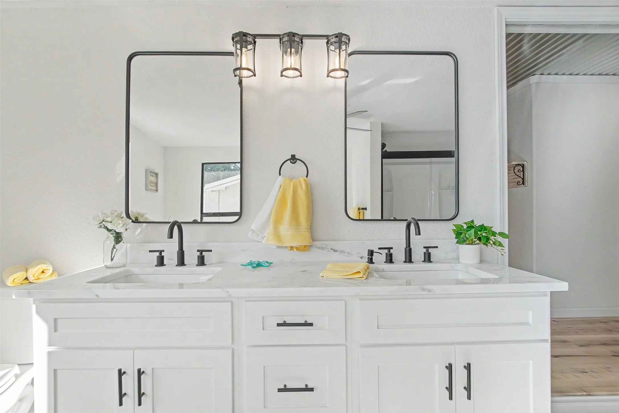 Dual vanity featuring a stone countertop, integrated sinks, and matte black fixtures