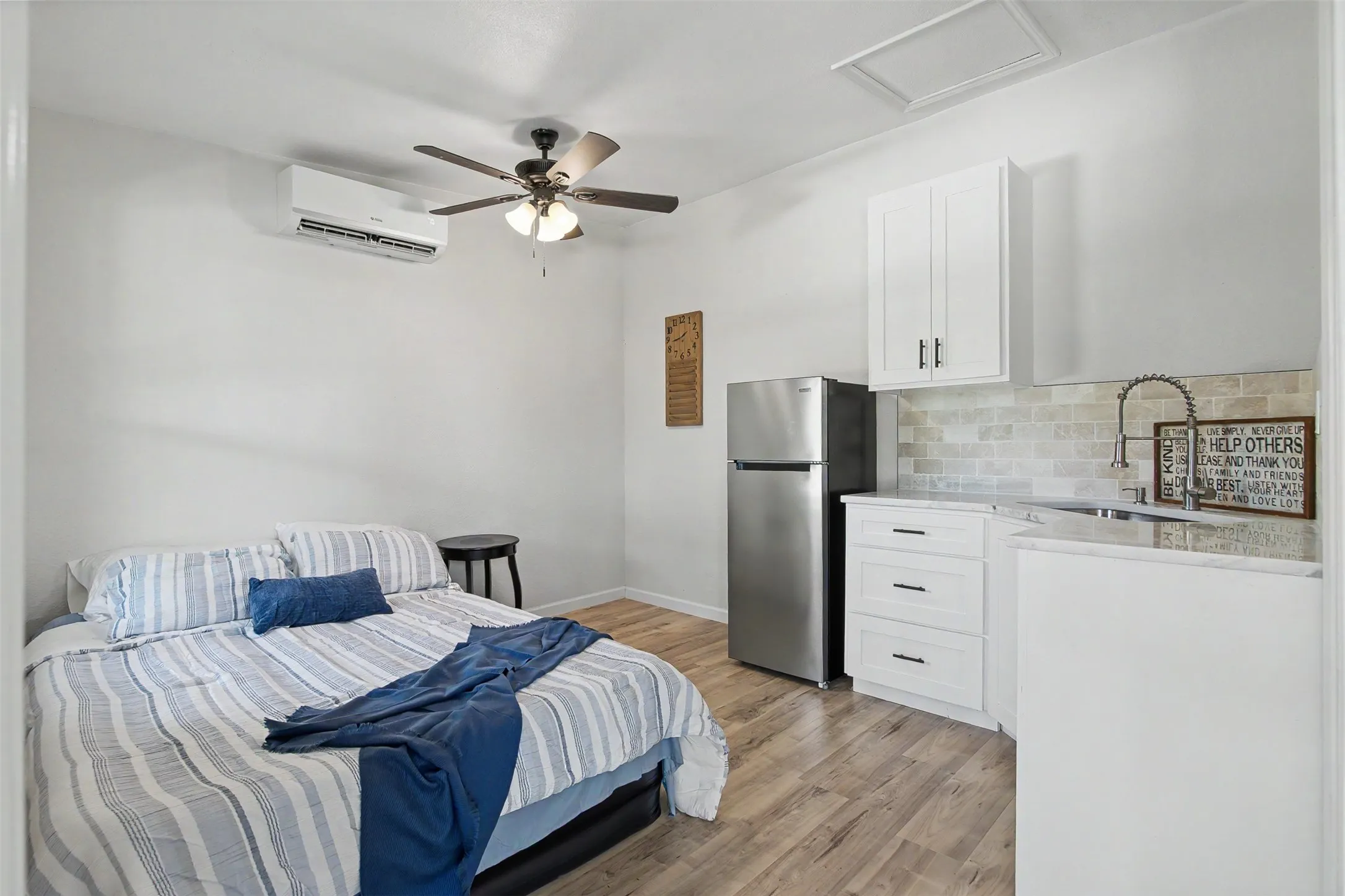 Interior space featuring wood-finish flooring, a ceiling fan, and a wall-mounted air conditioning unit