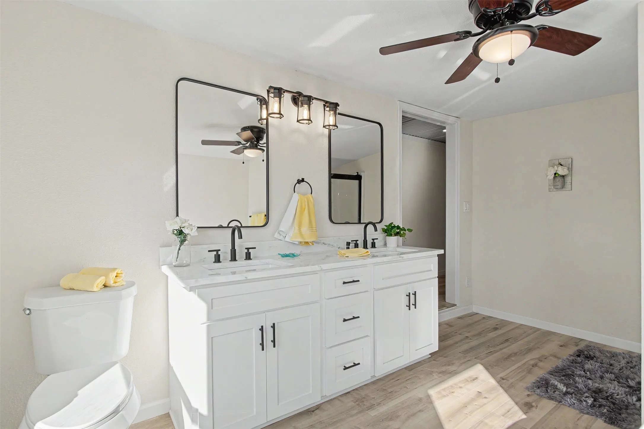 Bathroom featuring a double vanity with white cabinetry and a light-colored countertop
