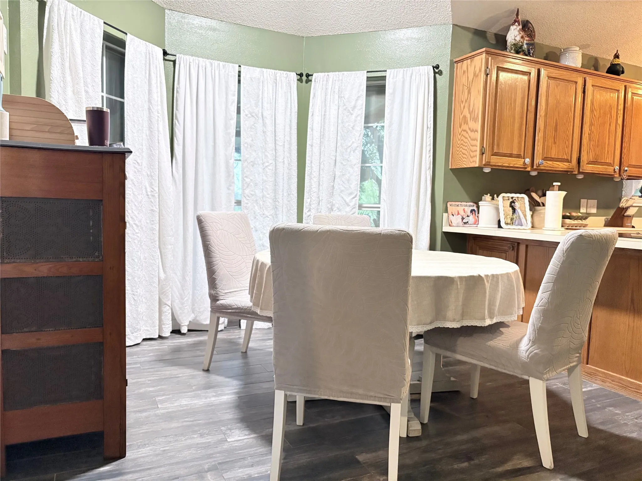Dining space with dark wood-style flooring and a textured ceiling