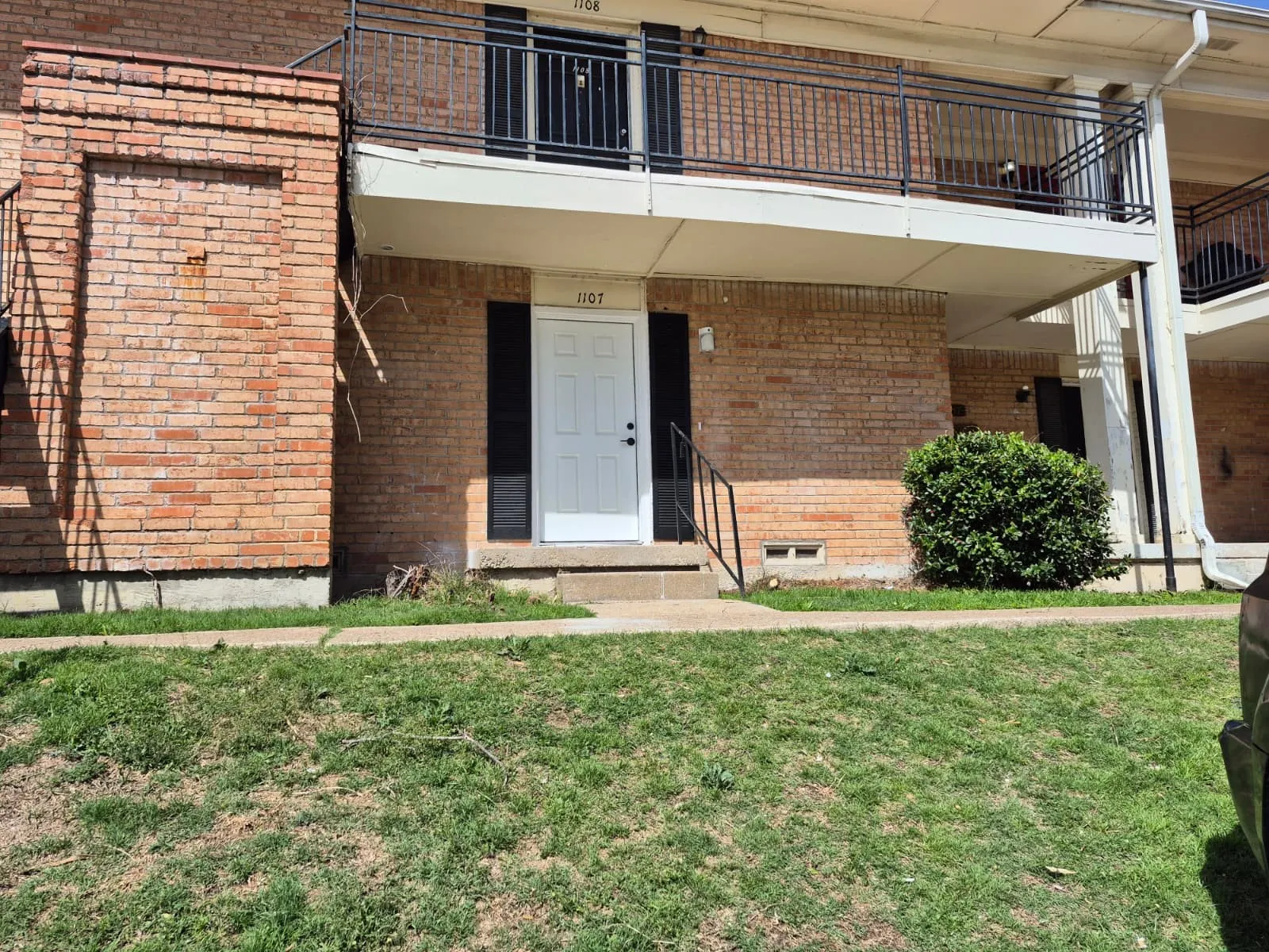 Entrance to property featuring brick siding and a lawn