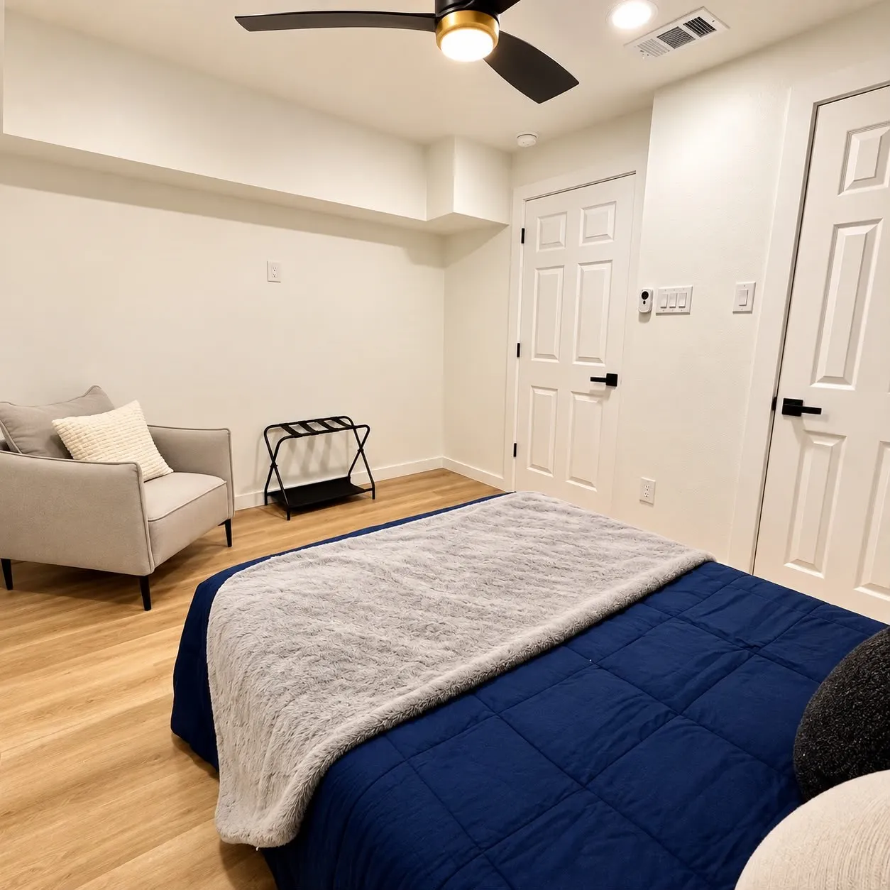 Wood-finish flooring, recessed lighting, ceiling fan with light, and paneled doors with matte black hardware