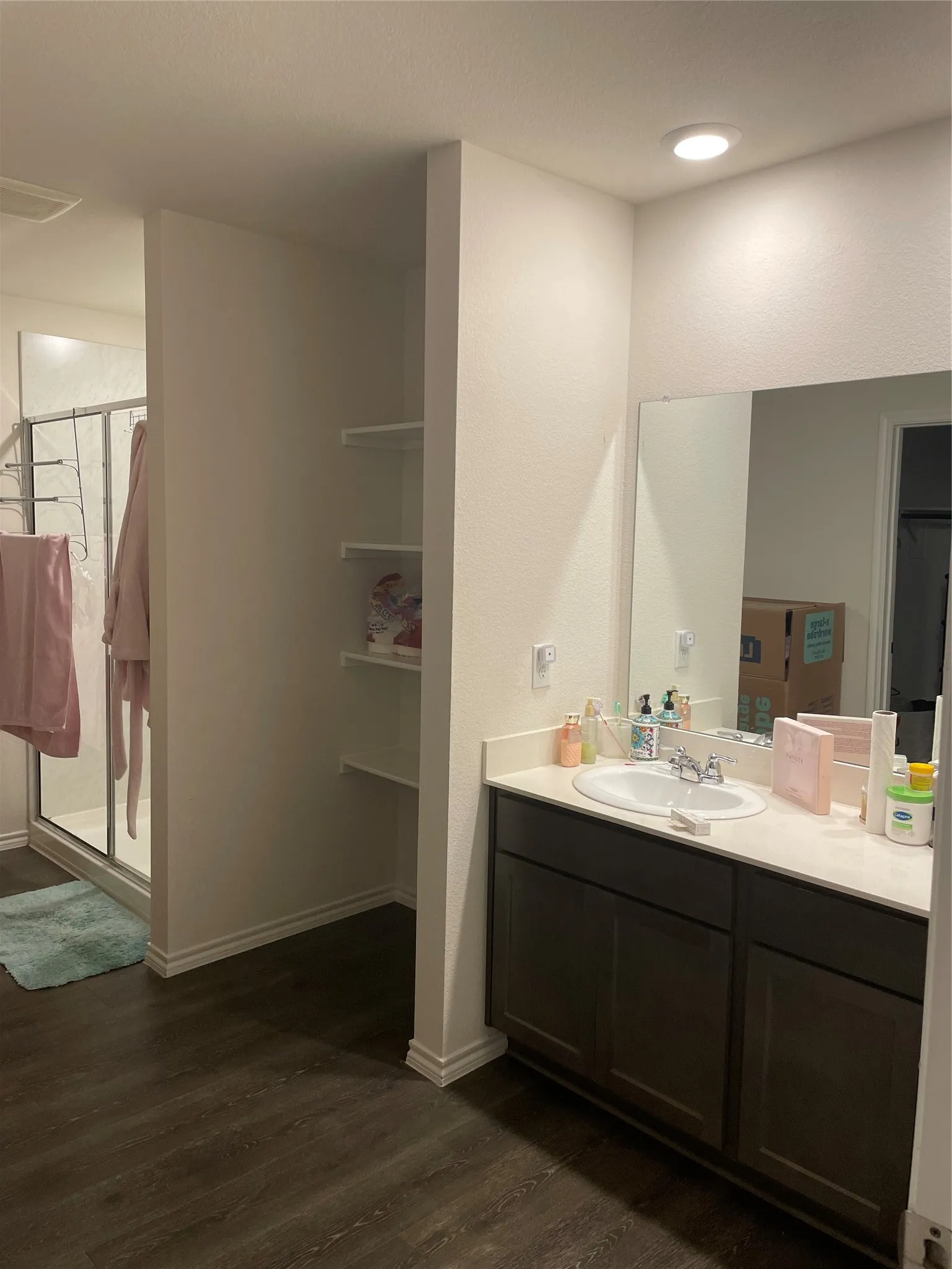 Full bathroom with vanity, a stall shower, and dark wood-style flooring