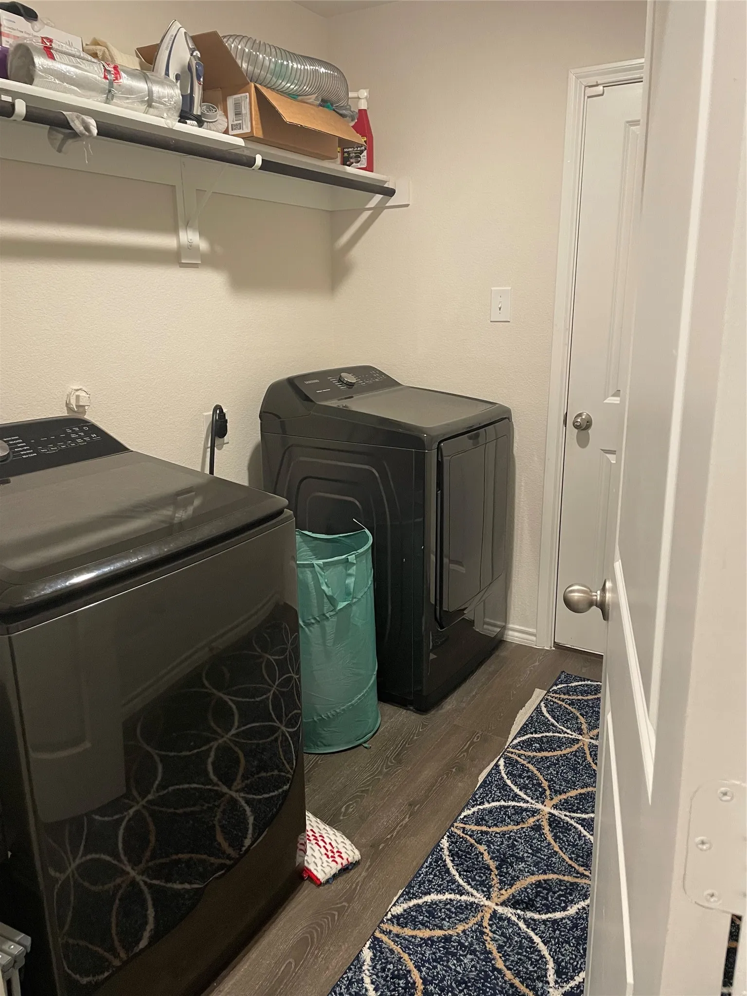 Laundry room featuring dark wood-style floors and washing machine and dryer