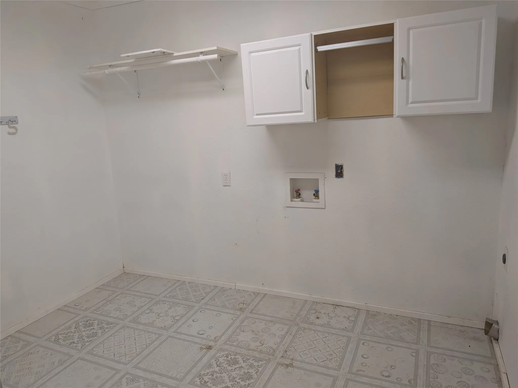 Laundry room with washer hookup, cabinet space, and light flooring