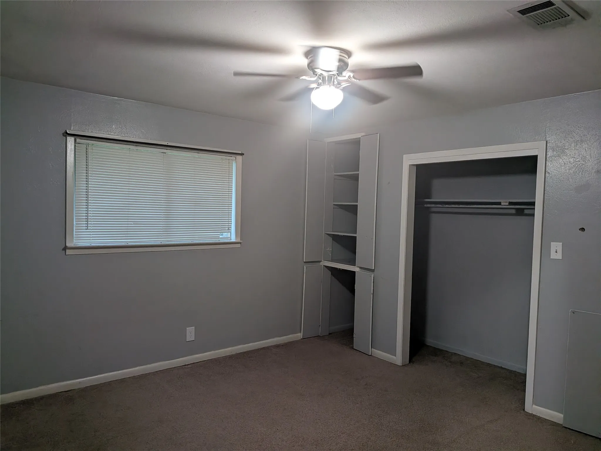 Unfurnished bedroom with light carpet, ceiling fan, and a closet