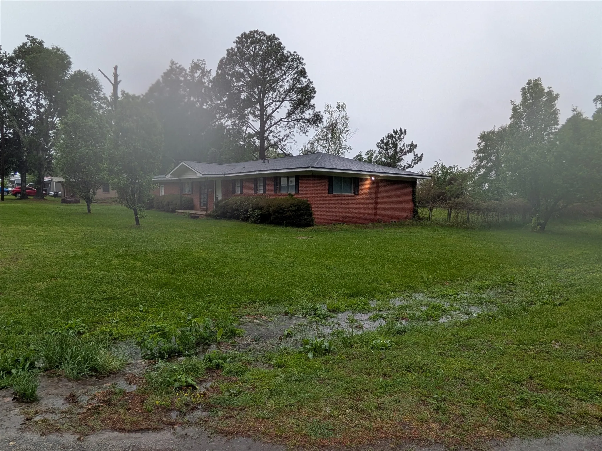 View of side of property with a lawn and brick siding