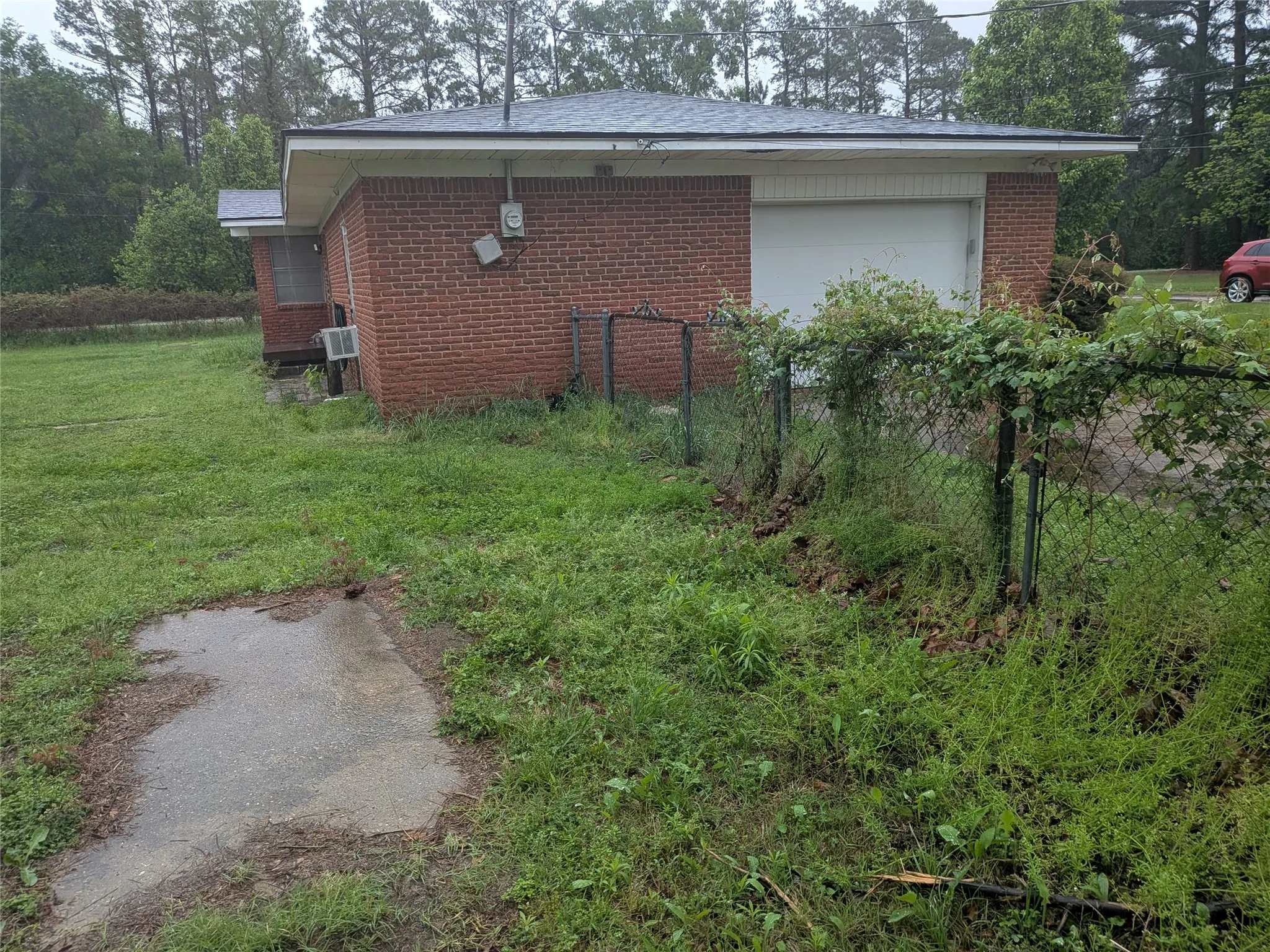 View of side of property with brick siding and an attached garage