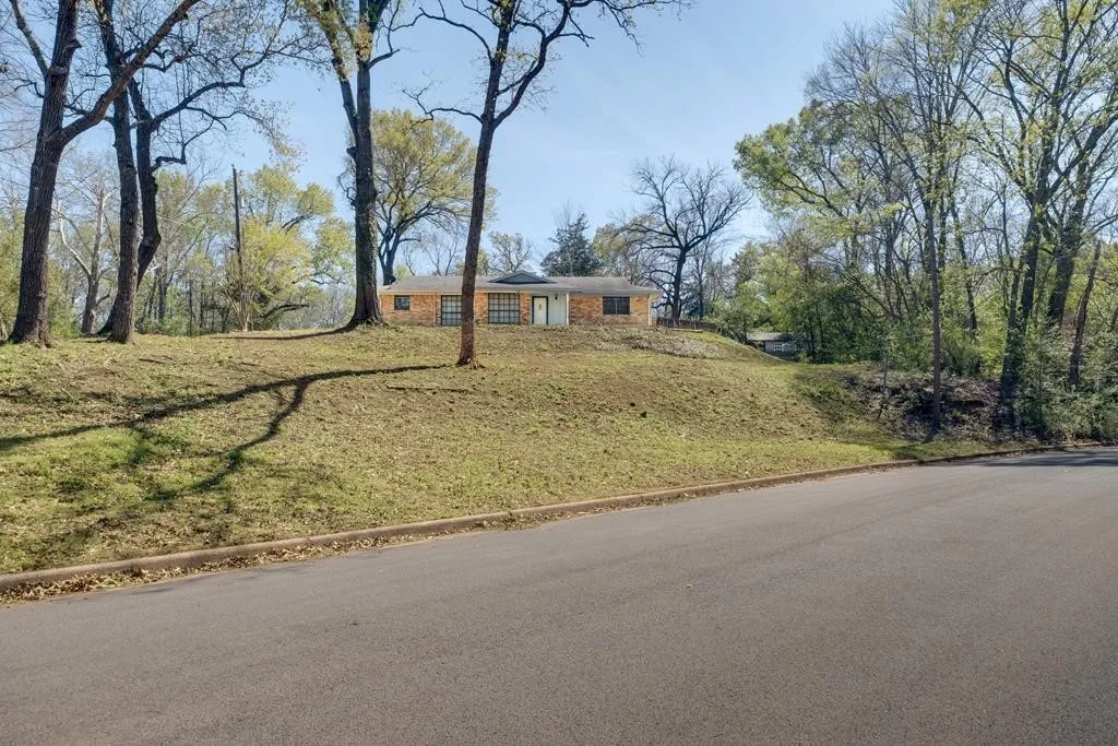 View of front of house with brick siding and a front lawn