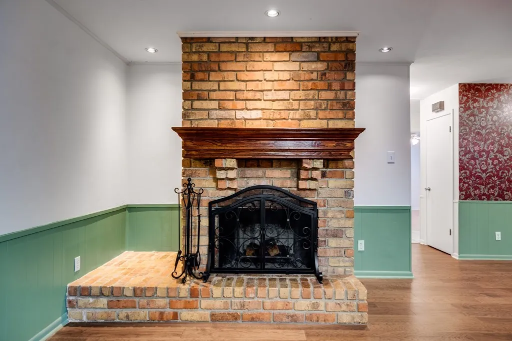 Detailed view of wainscoting, wood finished floors, and a fireplace