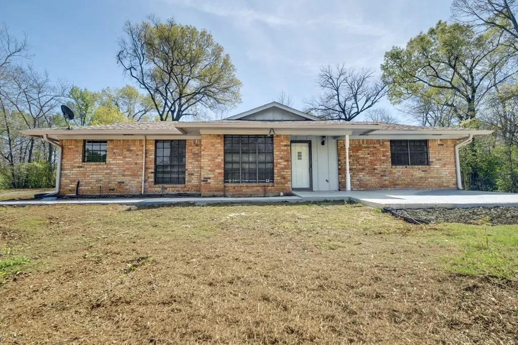 Single story home with brick siding, a front lawn, and a porch