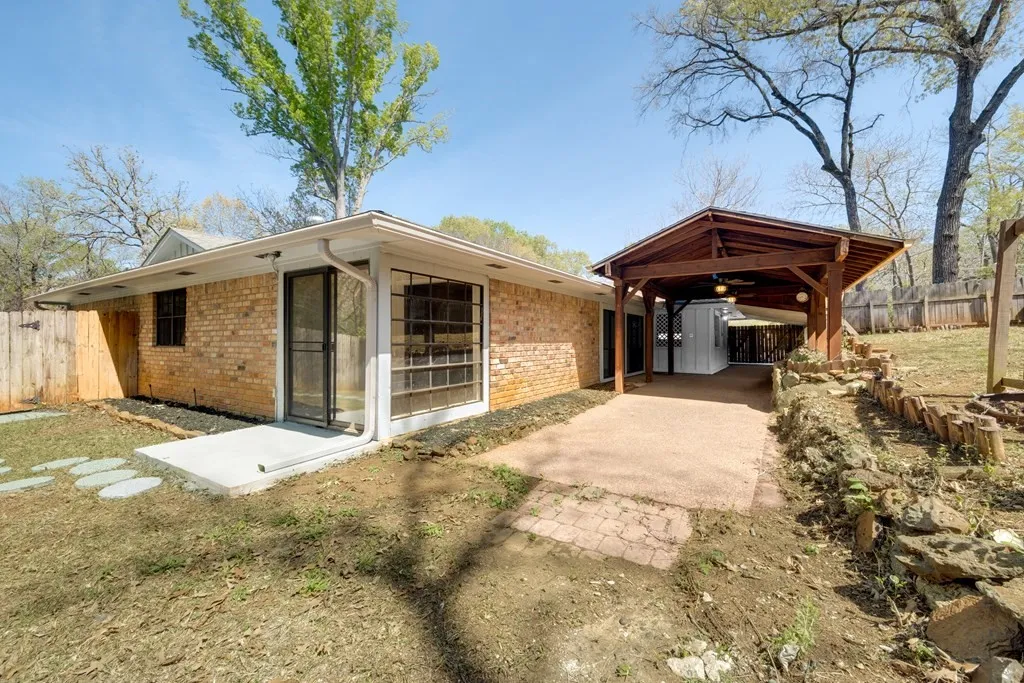 Rear view of property featuring brick siding and a patio area