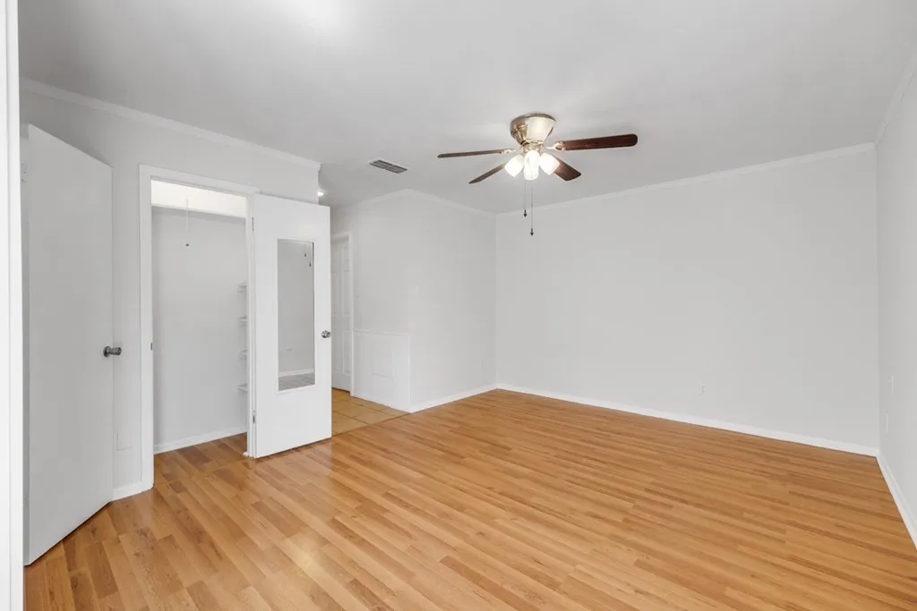 Spare room featuring ornamental molding, light wood-type flooring, and ceiling fan