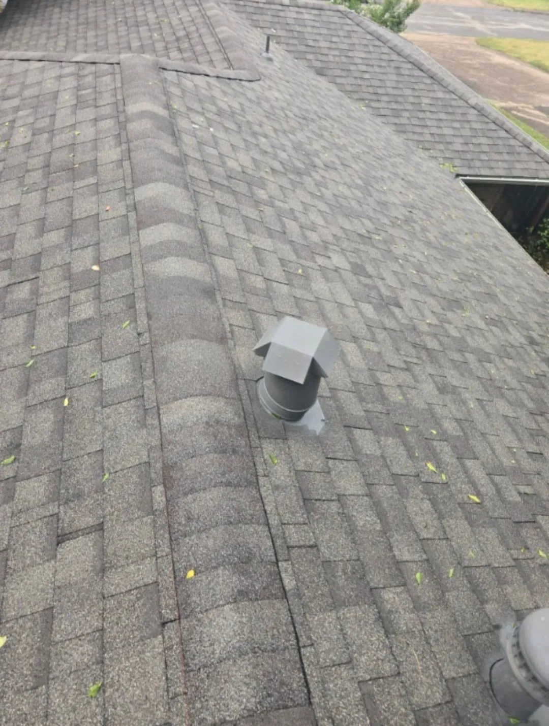 Asphalt shingle roof with multiple roof planes and a central ridge vent