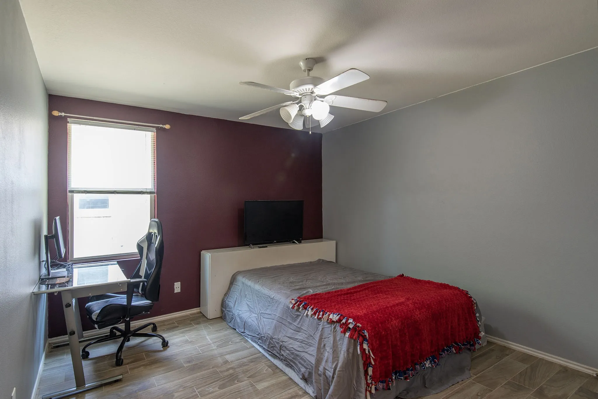 Bedroom with wood finish floors, a desk, and ceiling fan