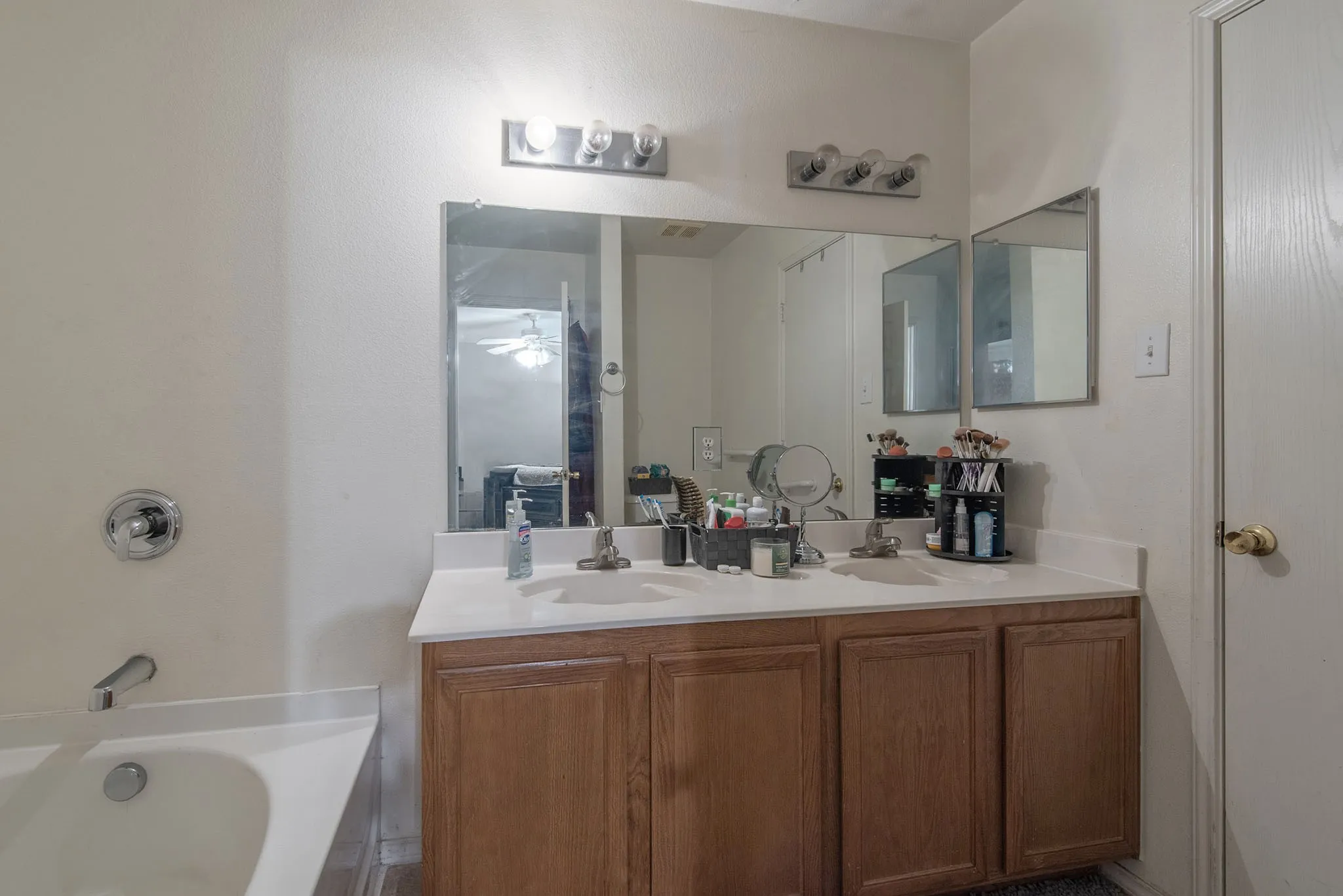 Bathroom featuring double vanity, a tub, and a shower