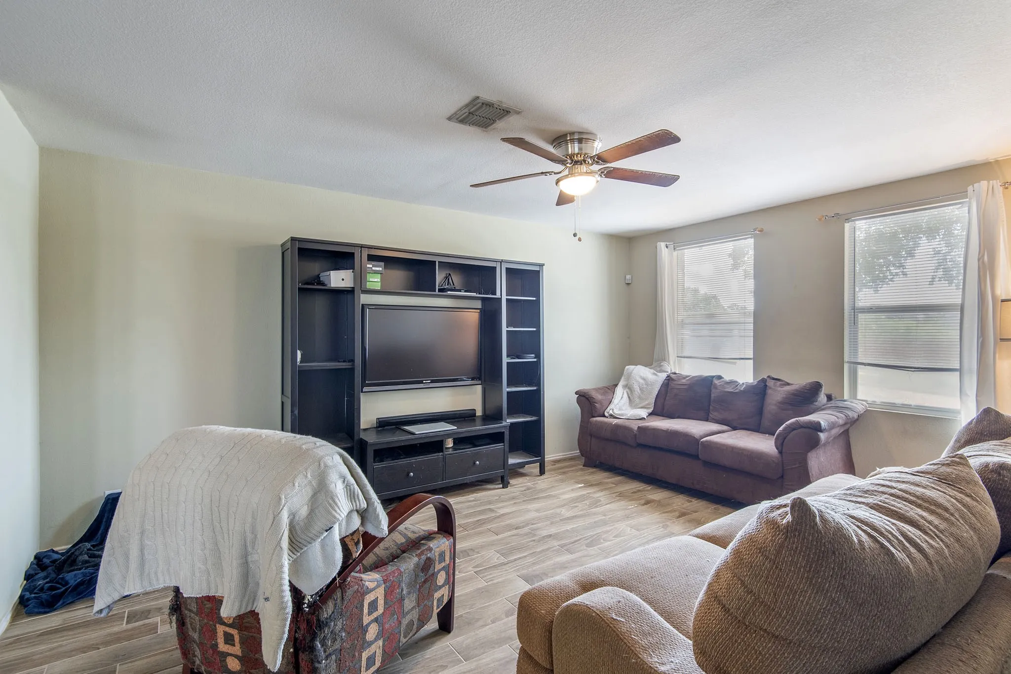Living room with wood tiled floors and a ceiling fan