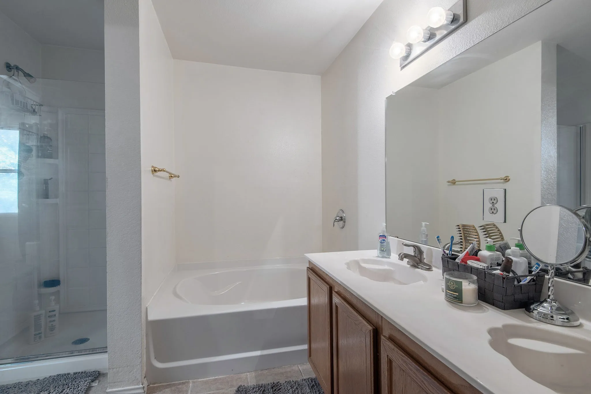 Bathroom with a stall shower, double vanity, and a bath