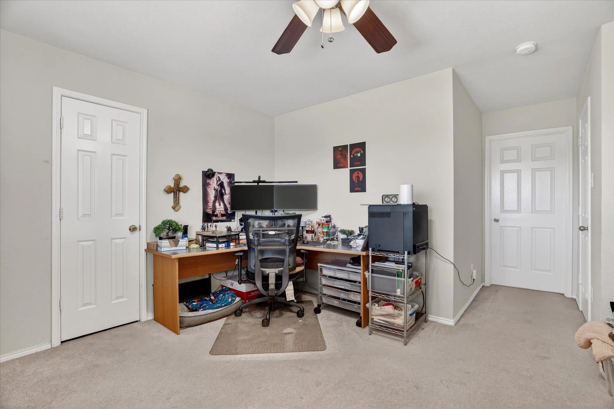 Carpeted room featuring a ceiling fan with integrated lighting, neutral wall tones, and white paneled doors