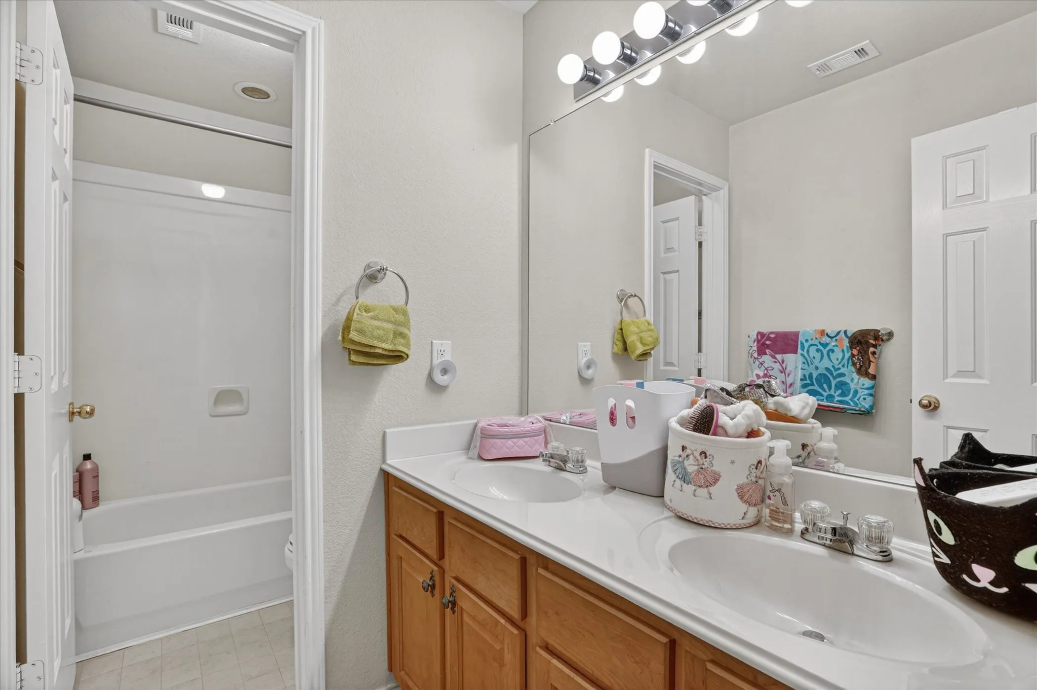 Double vanity with integrated sinks, laminate countertops, and wood-finish cabinetry