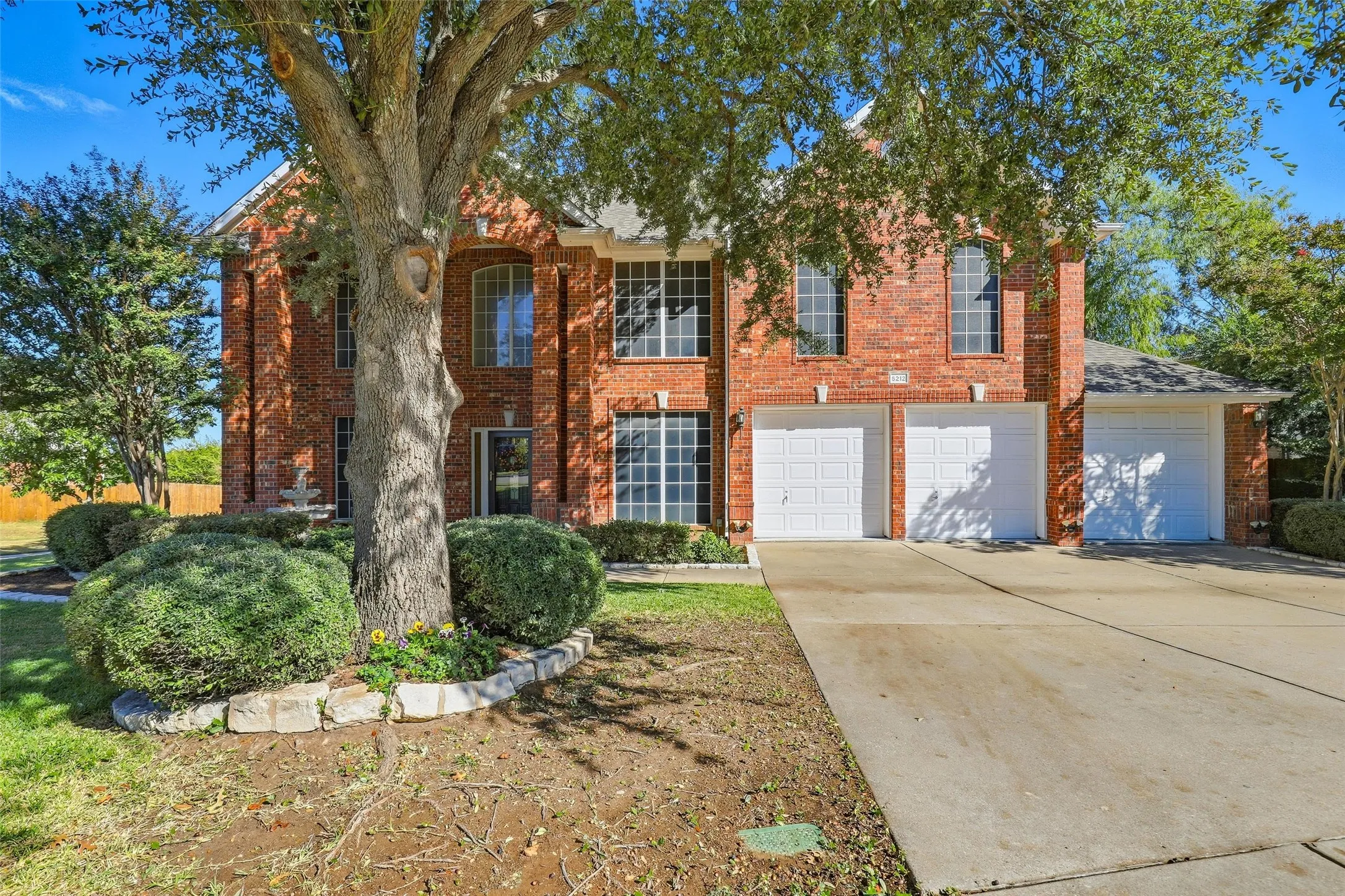 View of front facade featuring concrete driveway, brick siding, and a garage