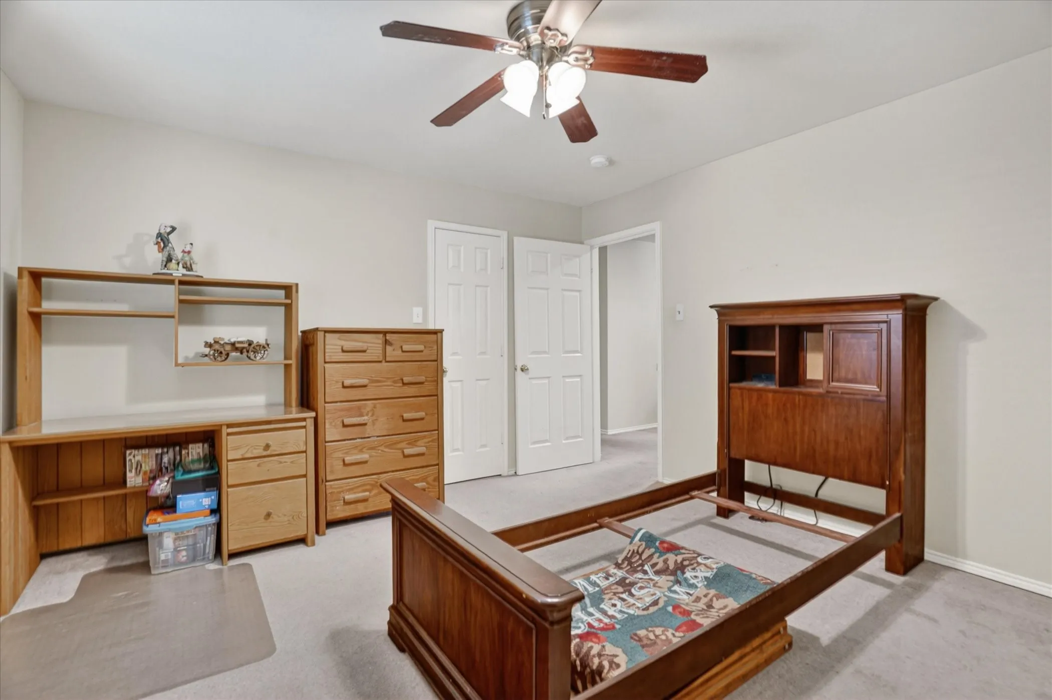 Carpeted room with light neutral walls and a ceiling fan