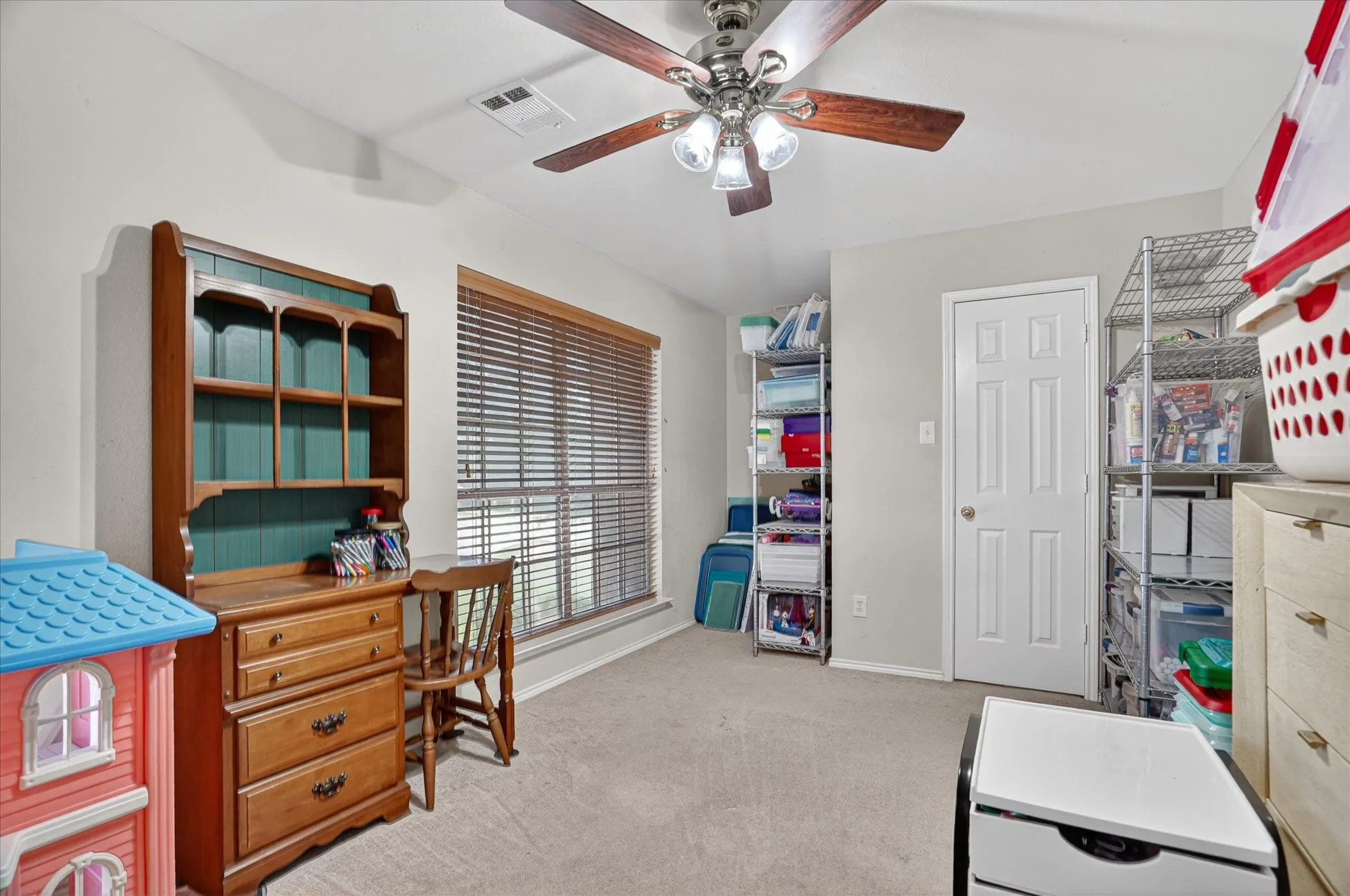Interior room featuring light gray walls, plush carpet flooring, and a ceiling fan with light fixture