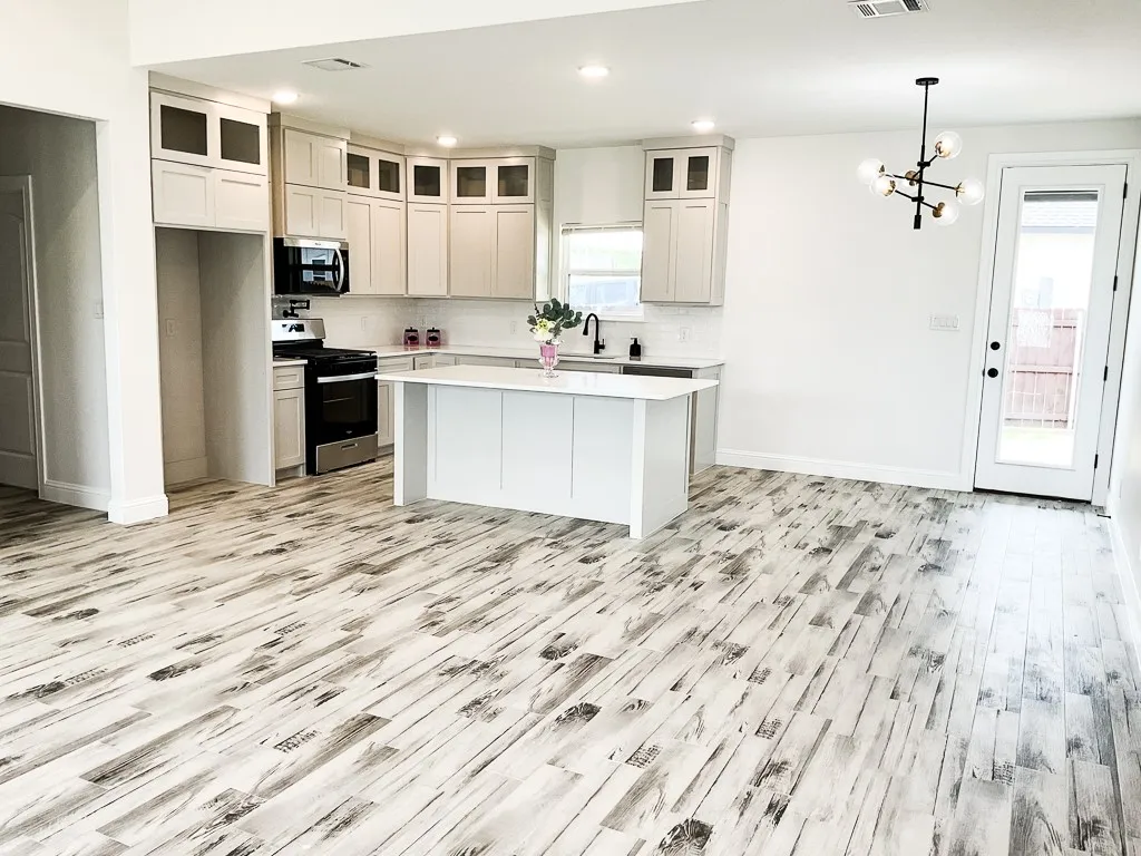 Kitchen has custom wood cabinets, stainless steel appliances, pot filler and gas stove.