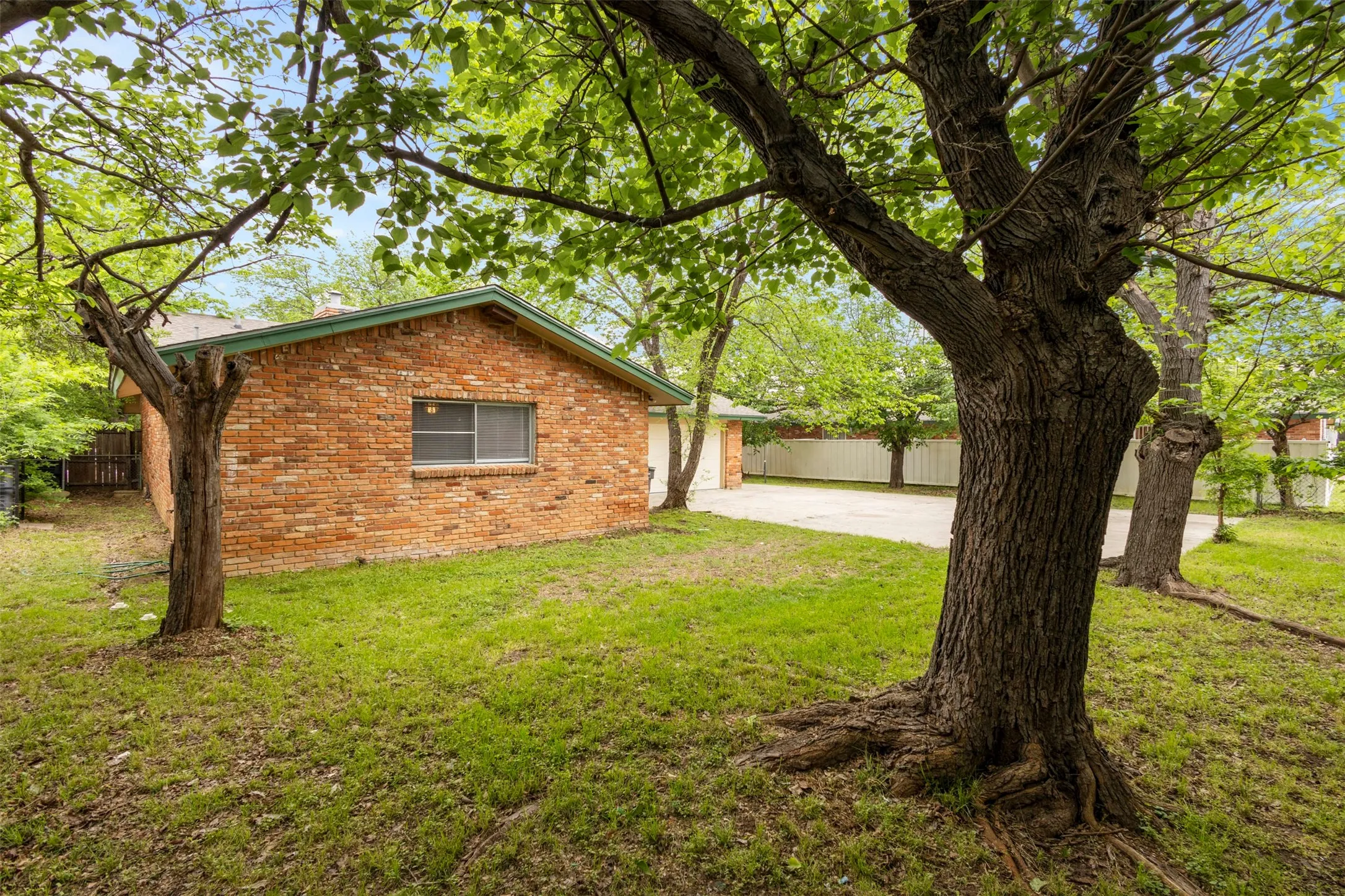 View of side of home featuring brick siding and driveway