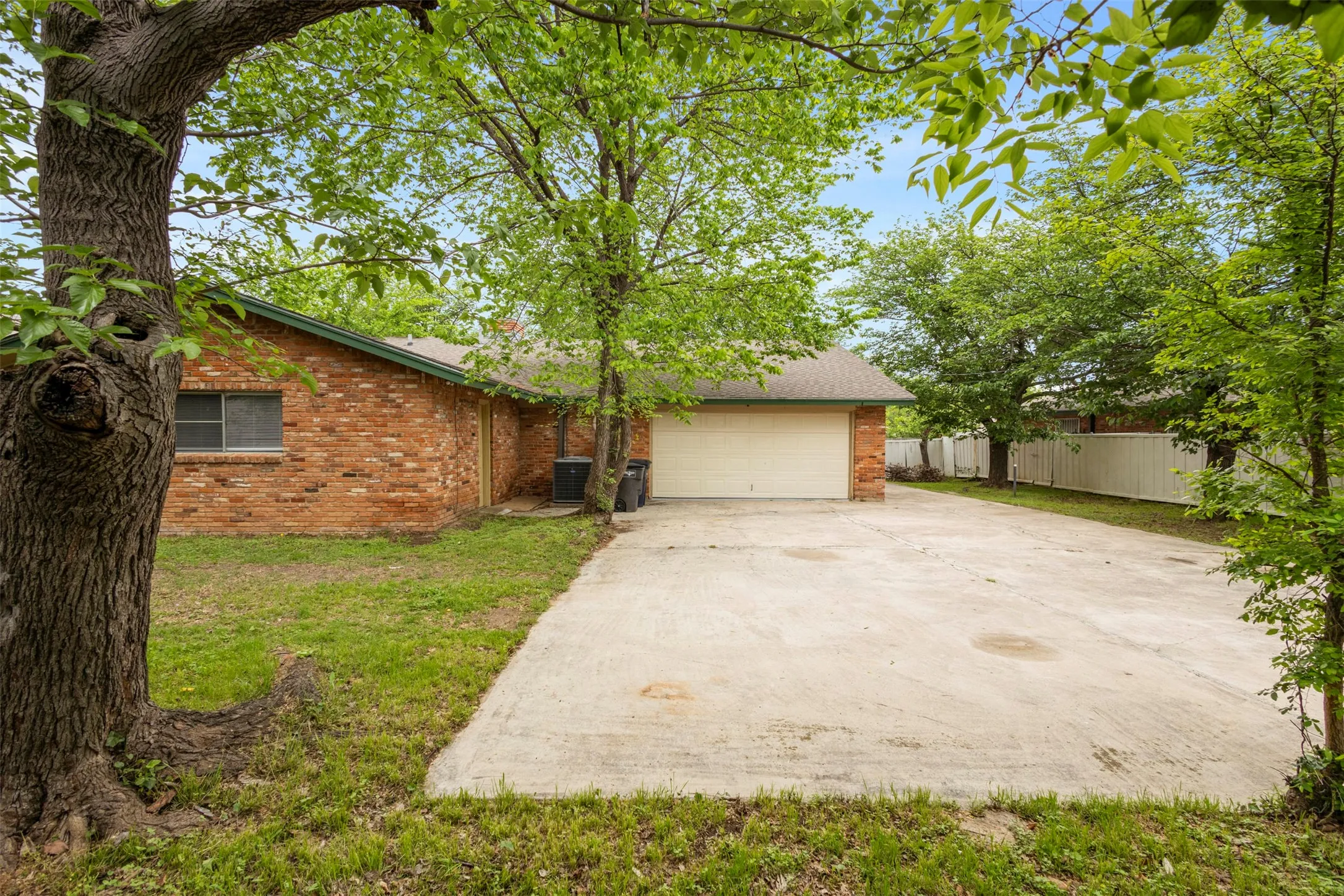 View of front of property with brick siding, concrete driveway, and a garage