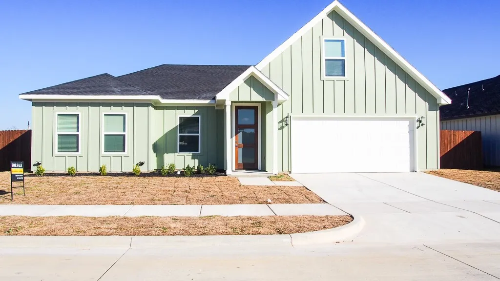 Contemporary exterior with vertical siding, dark shingle roof, integrated two-car garage, and a concrete driveway