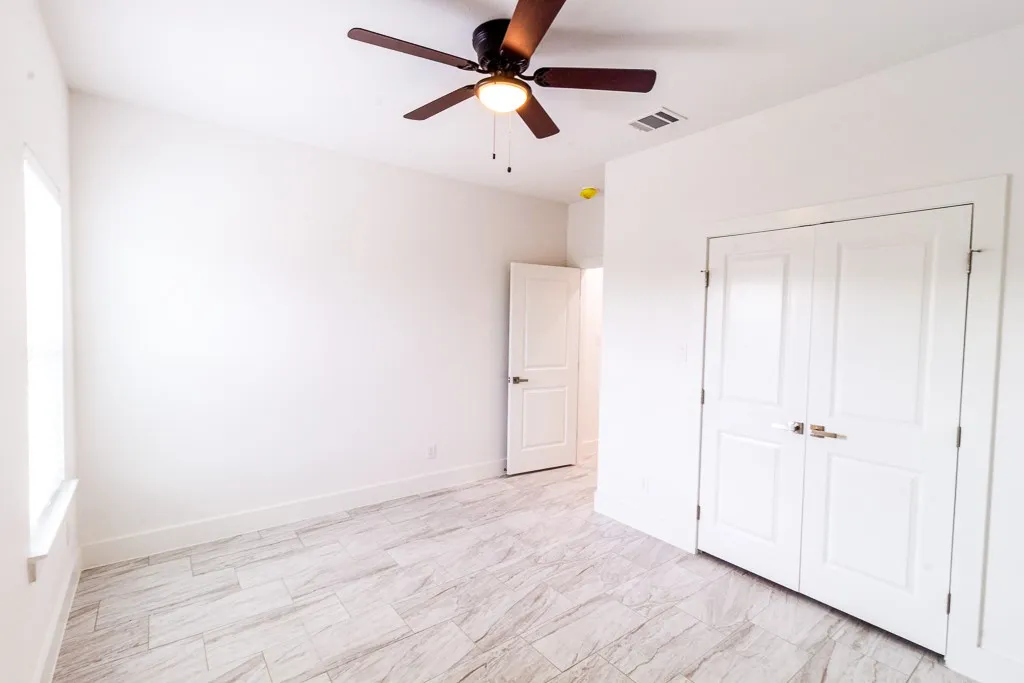 Recessed lighting, wood-finish ceiling fan, white paneled doors, and light-toned tile flooring