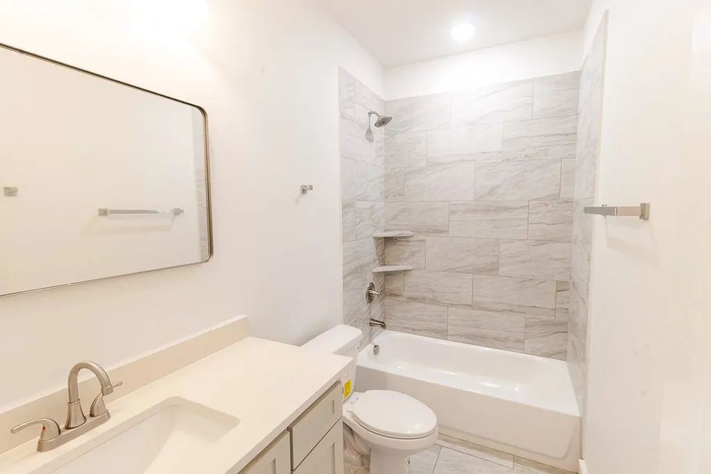 Bathroom featuring a white vanity with an undermount sink, brushed nickel faucet, and a large rectangular mirror
