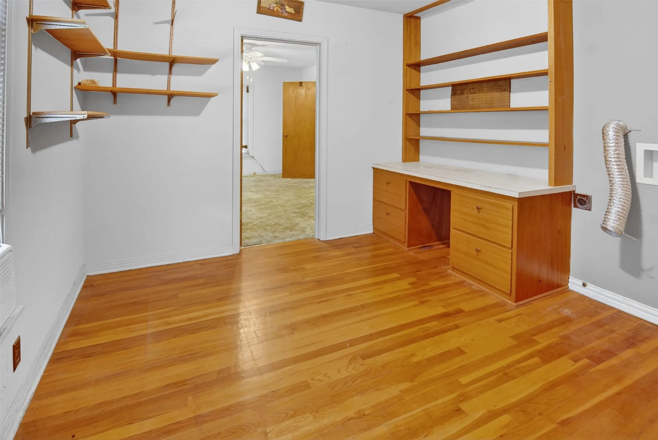 First bedroom features built in desk and shelving, and wood type flooring. Space for stackable washer and dryer with connections in place.