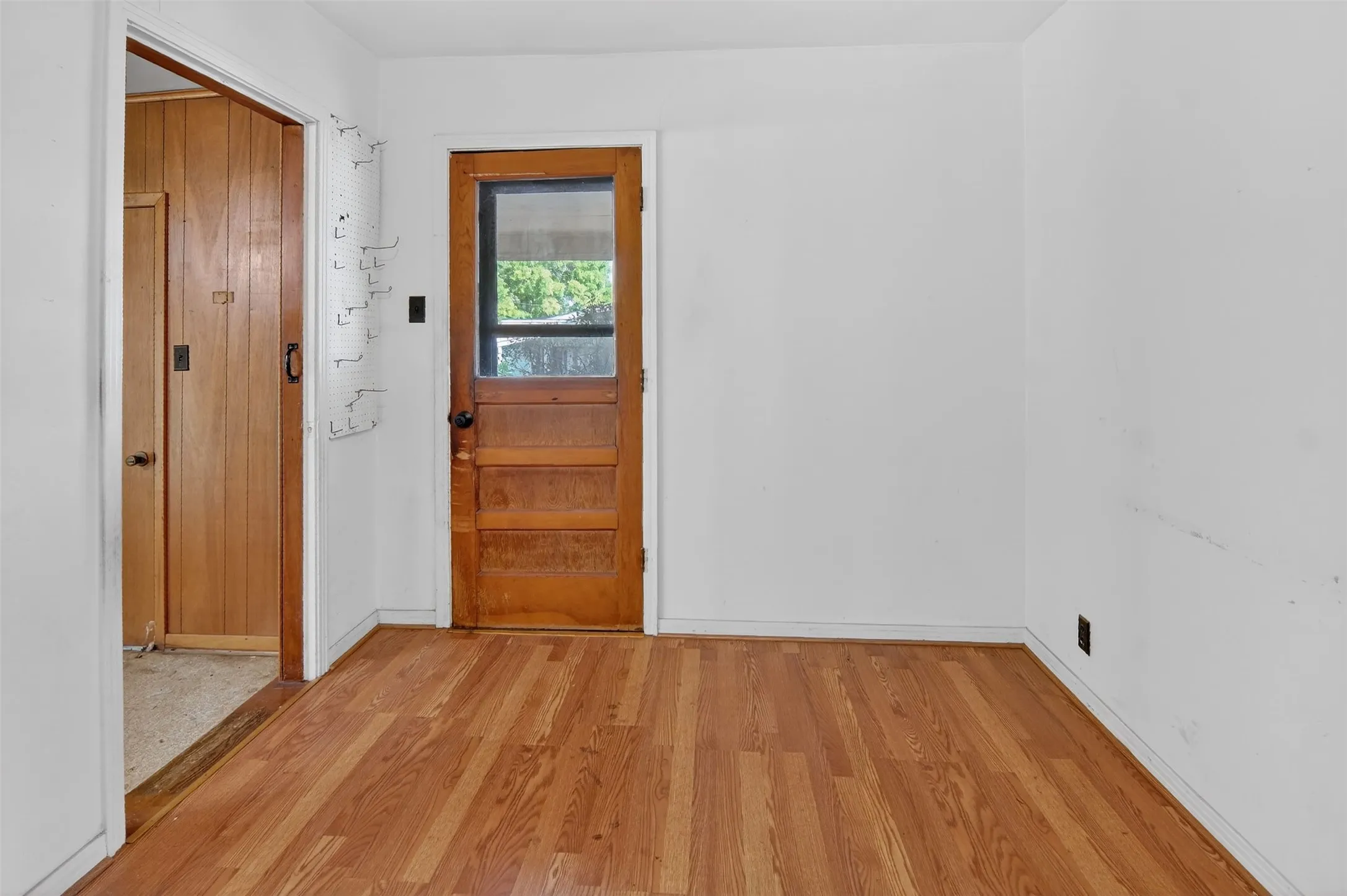 Dining area with wood type flooring, and door to side carport and storage area.