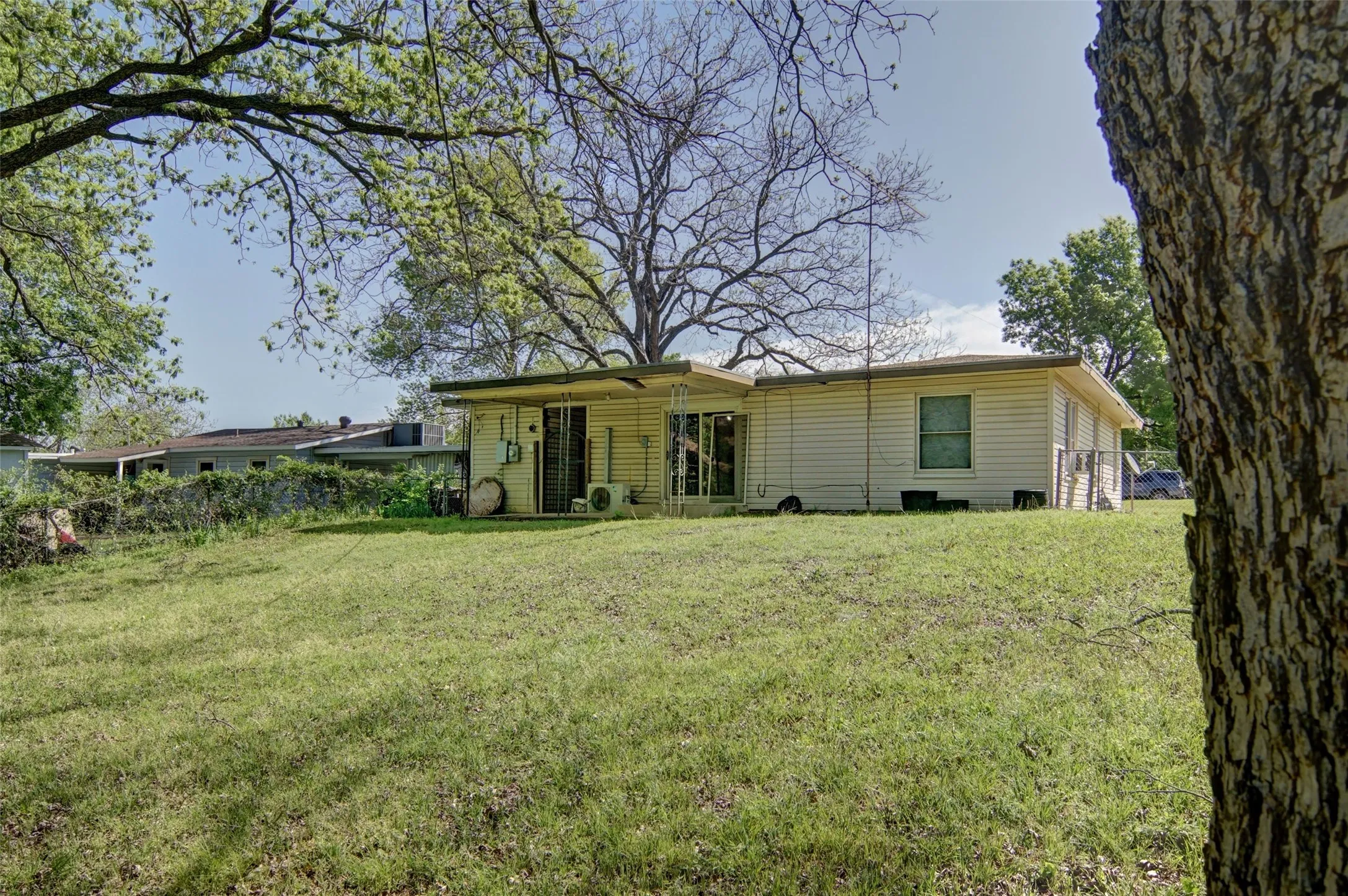 Rear view of home featuring a large lawn.