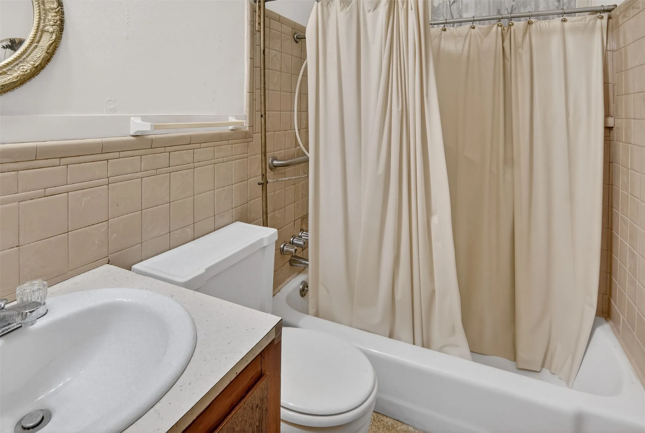 Full bath #2 with shower / tub combo, vanity, and tile walls.