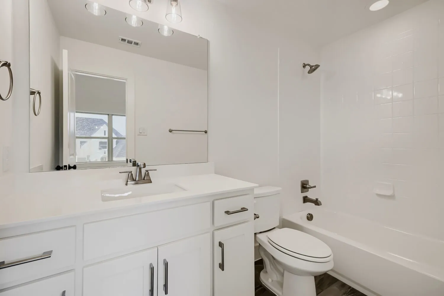 White vanity with an integrated sink, brushed nickel faucet, and coordinating hardware