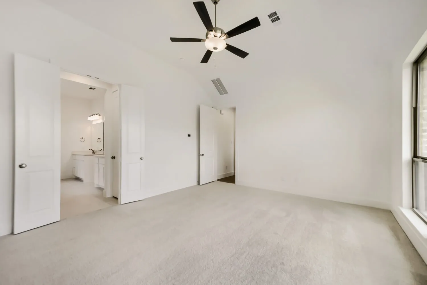 Spacious room featuring light-colored carpeting and a modern ceiling fan with integrated lighting